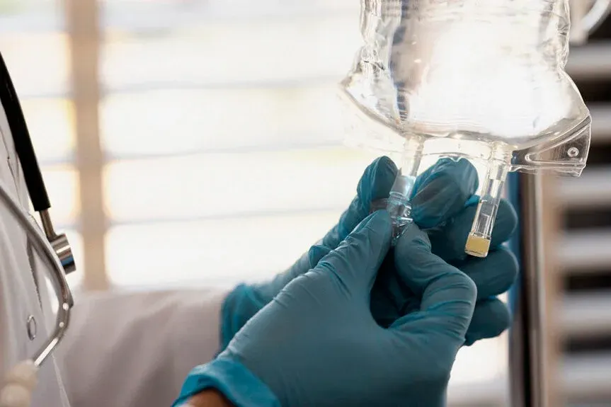 CagriSema Weight Loss Drug: New Results in Clinical Trials a person in a white coat and blue gloves is holding a sys CagriSema in their hand and a light bulb is in the background